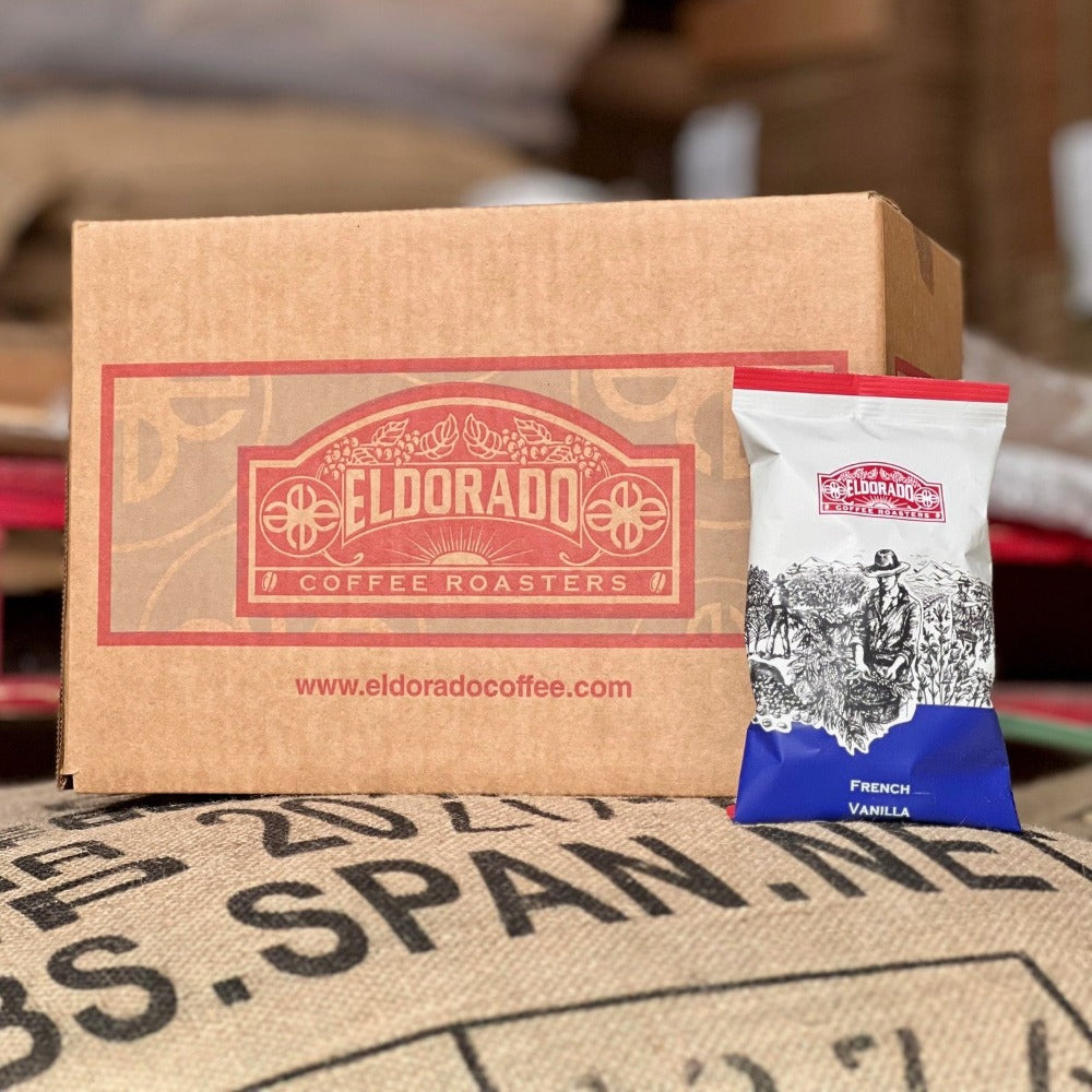 A bag of Eldorado Coffee Roasters French Vanilla coffee leans against a branded box, promising a delicious caffeine experience.
