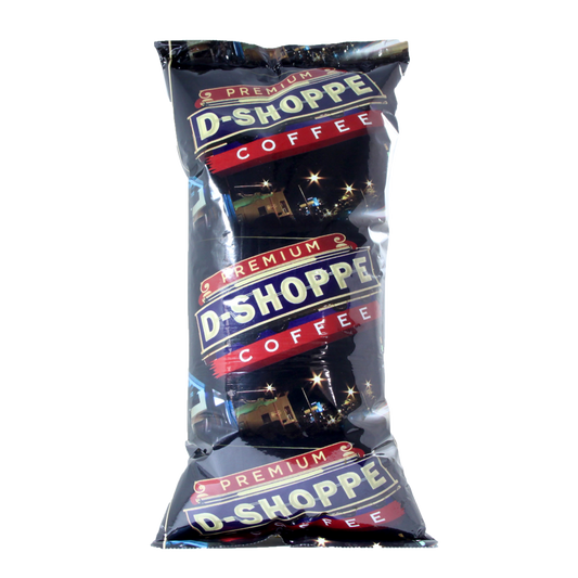 A glossy black bag of premium D-Shoppe coffee stands upright, showcasing its night-themed branding with a city skyline and twinkling lights.