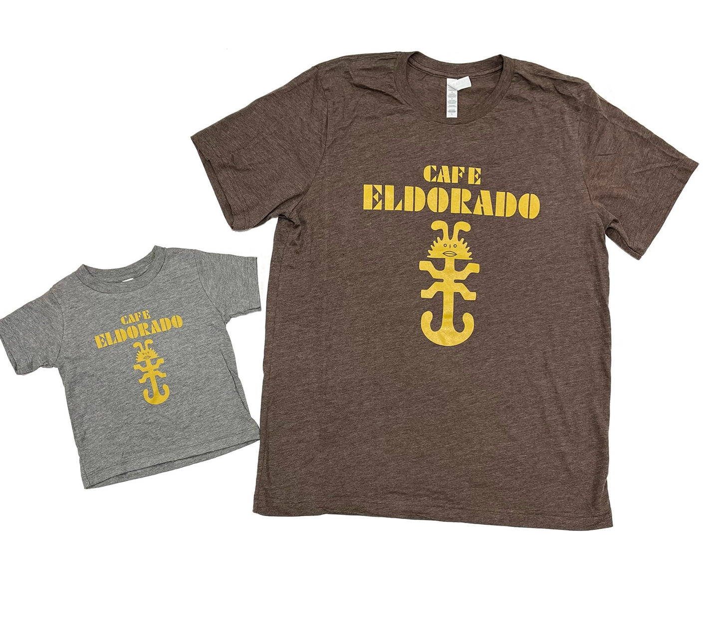 Two t-shirts, adult and youth sizes, display the "Cafe Eldorado" logo: bold yellow lettering above a stylized anchor and whimsical scorpion design.
