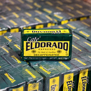 A green and yellow box of Cafe Eldorado decaffeinated espresso coffee sits atop a stack of more boxes. 
