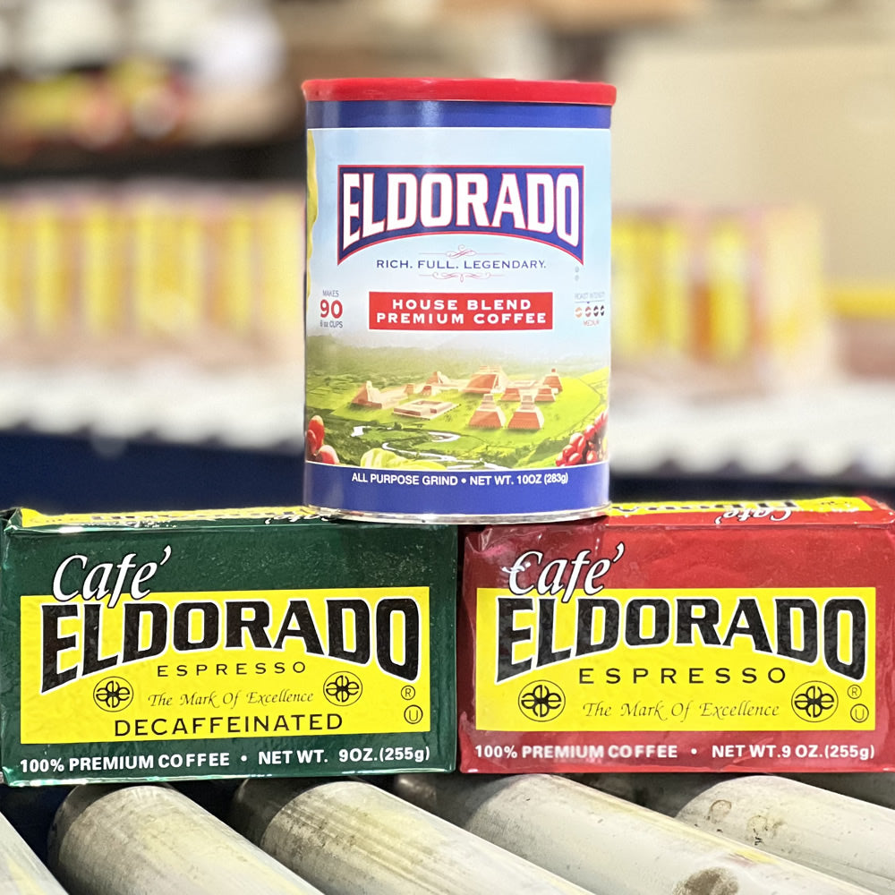 Three canisters of Cafe Eldorado coffee: a blue "House Blend" canister sits atop green "Decaf Espresso" and red "Espresso" canisters. 
