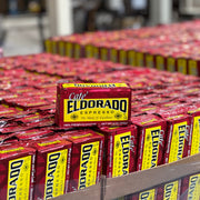 A stack of Cafe El Dorado Espresso coffee bags sits on a pallet, ready for distribution. 

