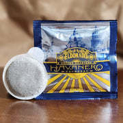 An El Dorado Coffee Roasters "Havanero Espresso" single-serve coffee pod rests in front of its foil packaging. 
