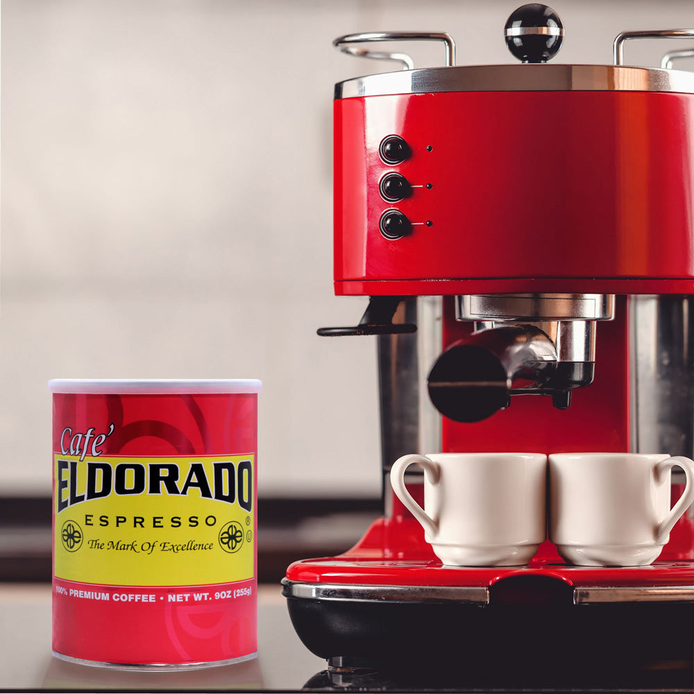 Red espresso machine brews Cafe Eldorado espresso into two white espresso cups. 
