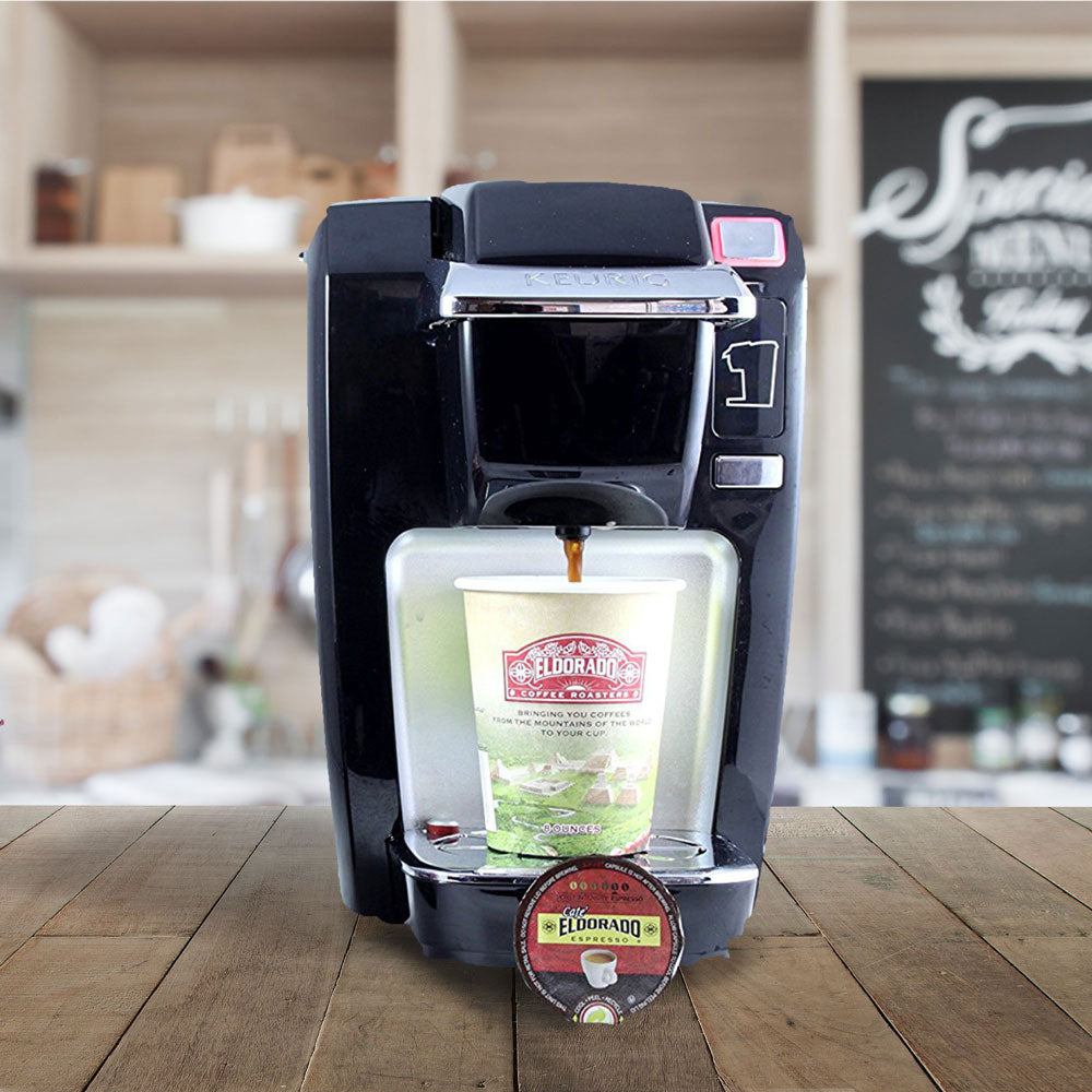 Black Keurig K-Compact single-serve coffee maker brews El Dorado Espresso into a to-go cup. 
