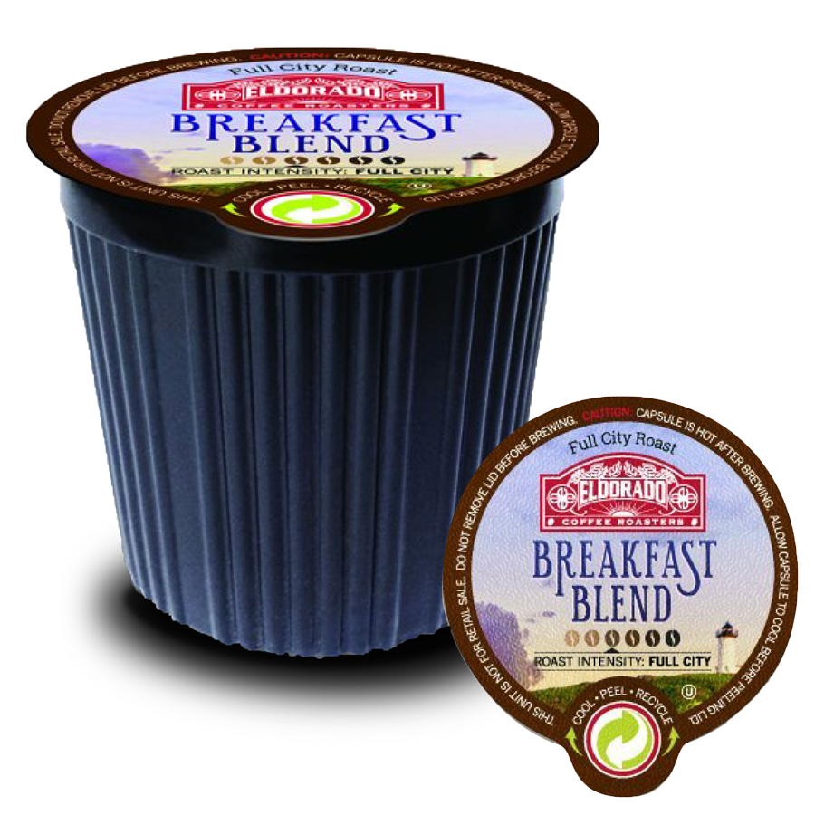 A single-serve El Dorado Coffee Roasters Breakfast Blend coffee pod rests on its foil lid.  The pod is black with a green recycling symbol and "Full City Roast" printed on the top. 
